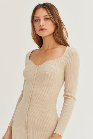 A model wearing an oatmeal sweater dress.