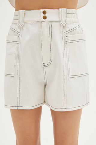 A woman wearing an ivory contrast topstitch shorts.