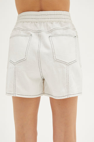 A woman wearing an ivory contrast topstitch shorts.
