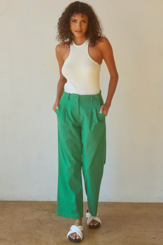 A woman wearing an emerald straight leg trousers.