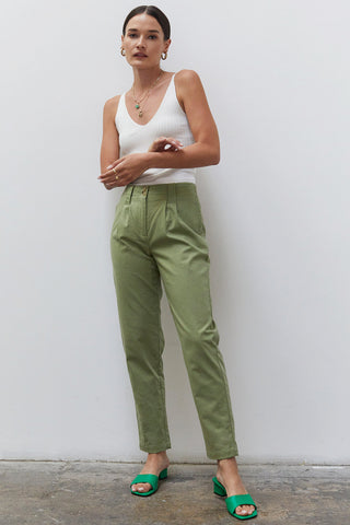 A woman wearing a moss linen tapered pants.