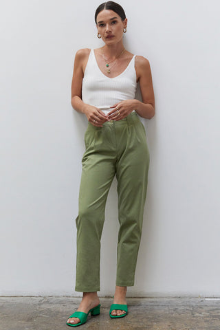 A woman wearing a moss linen tapered pants.