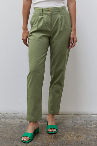 A woman wearing a moss linen tapered pants.