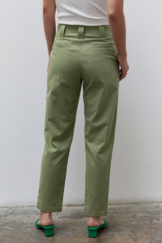 A woman wearing a moss linen tapered pants.
