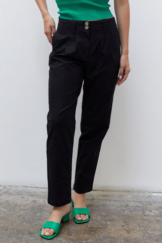 A woman wearing a black linen tapered pants.