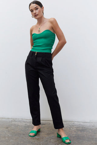 A woman wearing a black linen tapered pants.