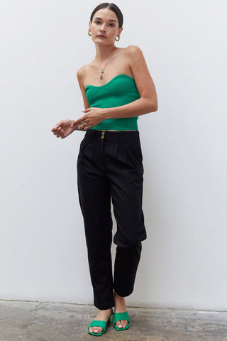 A woman wearing a black linen tapered pants.