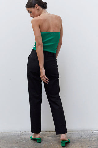 A woman wearing a black linen tapered pants.