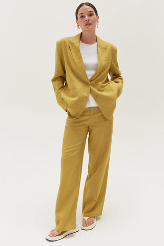 A woman wearing a key lime wide leg trousers with blazer set.