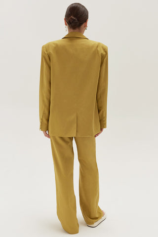 A woman wearing a key lime wide leg trousers with blazer set.