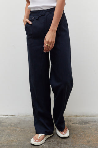 A woman wearing a navy wide leg trousers with blazer set.