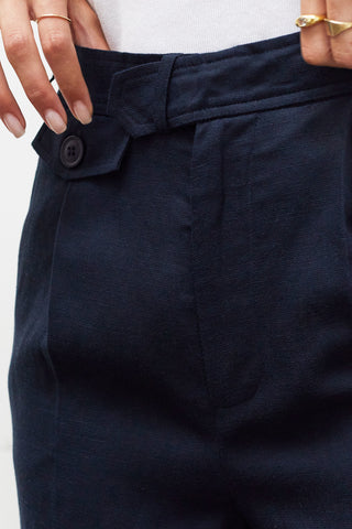 A woman wearing a navy wide leg trousers with blazer set.