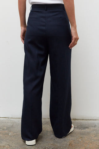 A woman wearing a navy wide leg trousers with blazer set.