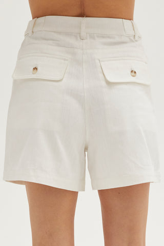 A woman wearing an ivory high rise shorts.