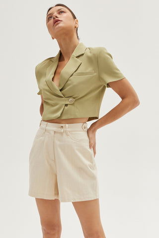 A woman wearing an oatmeal high rise shorts.