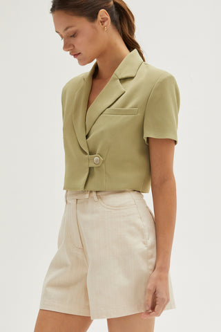 A woman wearing an oatmeal high rise shorts.