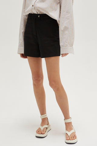 A woman wearing a black high rise shorts.