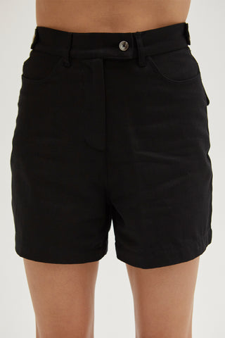 A woman wearing a black high rise shorts.
