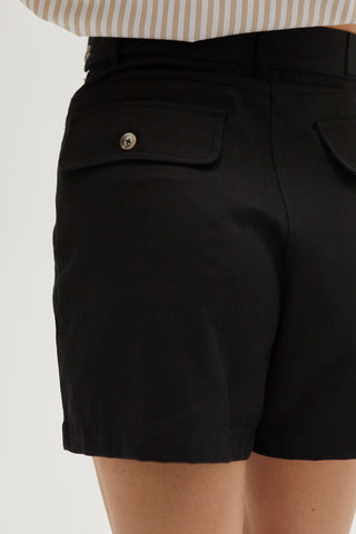 A woman wearing a black high rise shorts.