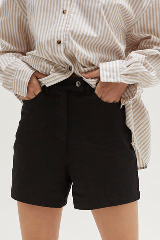 A woman wearing a black high rise shorts.