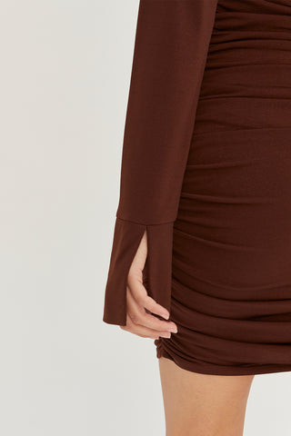 A model wearing a chocolate ruched mini dress.