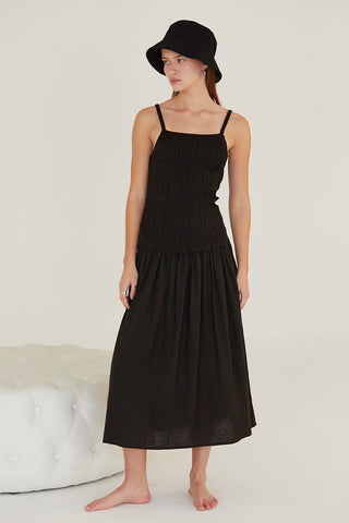 A model waring a black smocked bodice midi dress.