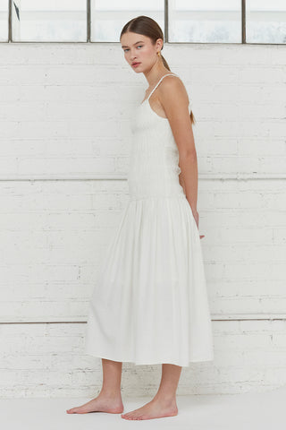 A model waring an ivory smocked bodice midi dress.