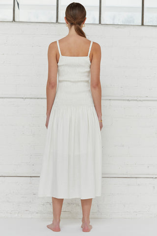 A model waring an ivory smocked bodice midi dress.