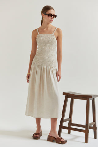 A model wearing an oatmeal smocked midi dress.