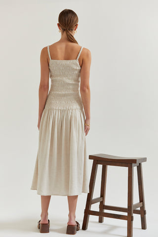 A model wearing an oatmeal smocked midi dress.
