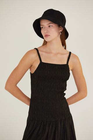 A model waring a black smocked bodice midi dress.