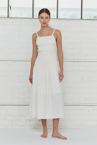 A model waring an ivory smocked bodice midi dress.