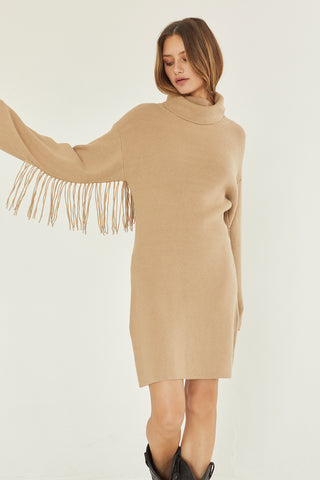 A model wearing a tan sweater dress.