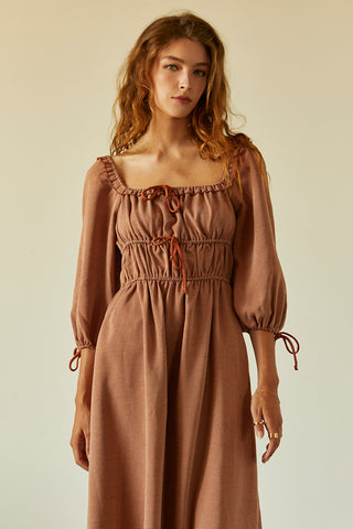 A woman wearing a rust jacquard midi dress.