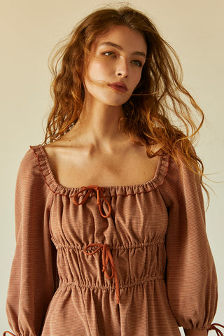 A woman wearing a rust jacquard midi dress.