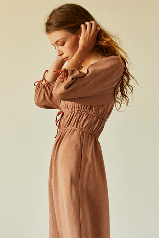 A woman wearing a rust jacquard midi dress.