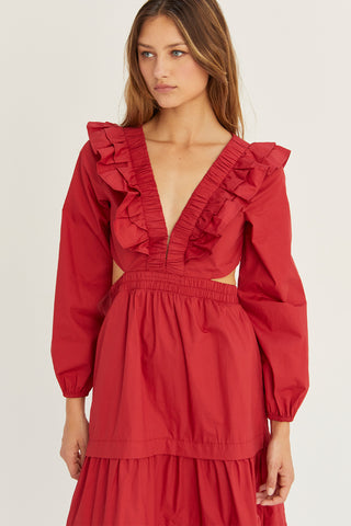 A woman wearing an oxblood tiered poplin maxi dress with back cut out details.