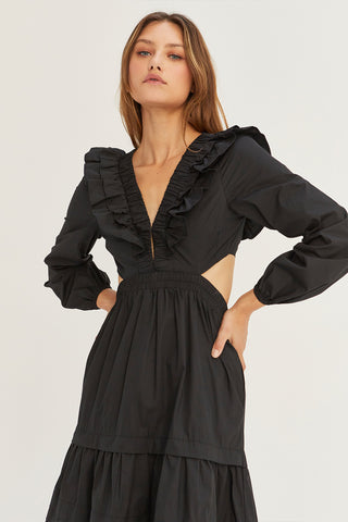 A woman wearing a black tiered poplin maxi dress with back cut out details.