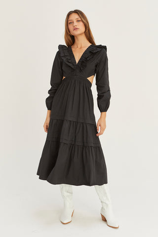 A woman wearing a black tiered poplin maxi dress with back cut out details.