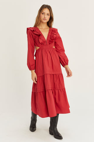 A woman wearing an oxblood tiered poplin maxi dress with back cut out details.
