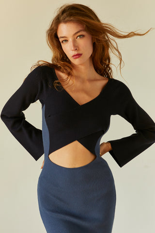 A model wearing a blue/navy color block knit midi dress.