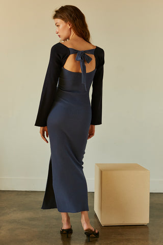 A model wearing a blue/navy color block knit midi dress.