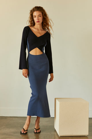 A model wearing a blue/navy color block knit midi dress.