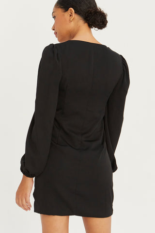 A model wearing a black satin balloon sleeve dress with asymmetric front button detail.