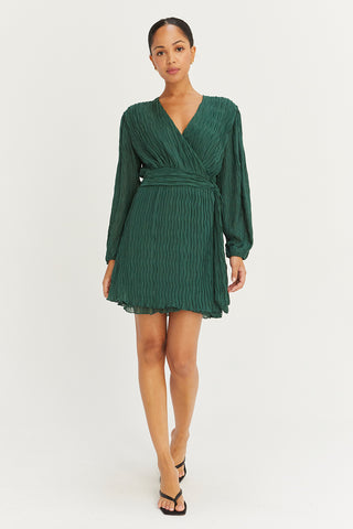 A model wearing a hunter green pleated chiffon wrap mini dress.
