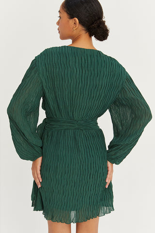 A model wearing a hunter green pleated chiffon wrap mini dress.