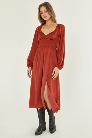 A model wearing a rust satin midi dress.