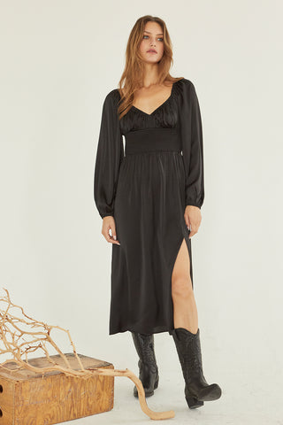 A model wearing a black satin midi dress.