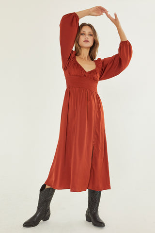 A model wearing a rust satin midi dress.