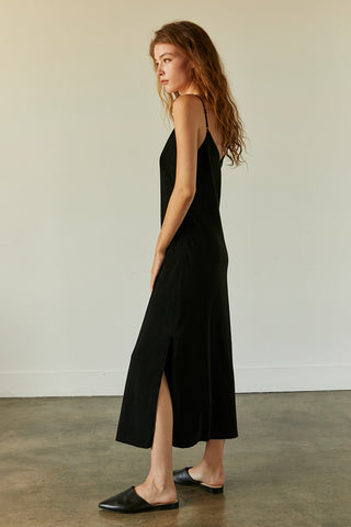 A model wearing a black pleated velvet midi dress.